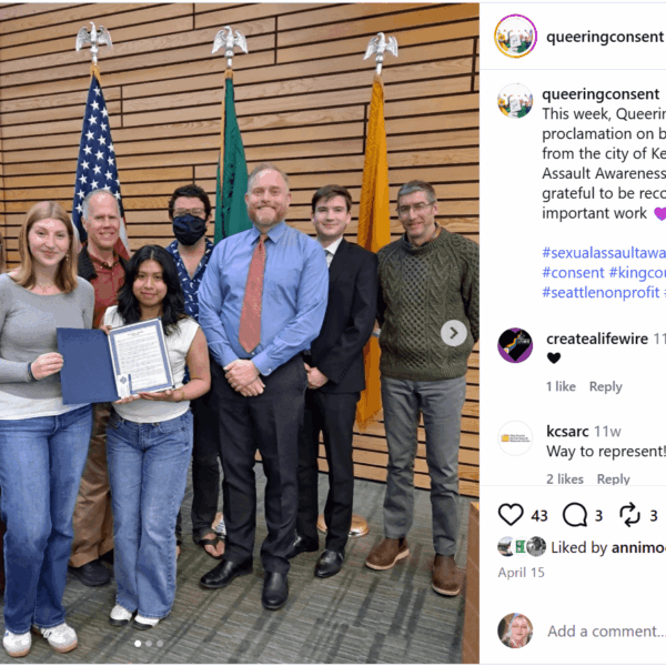 Social media post from Queering Consent account showing a group of people posing with two young people holding a Sexual Assault Awareness Month proclamation.